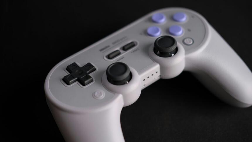 An image showing an 8Bitdo SN30pro+ controller kept on a dark deskmat.